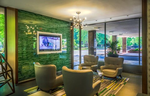 A lounge area with chairs and tv