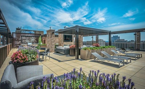A rooftop patio with seating and a fireplace