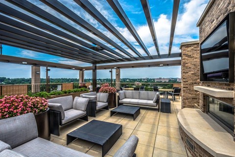 A patio with grey couches and a black coffee table.