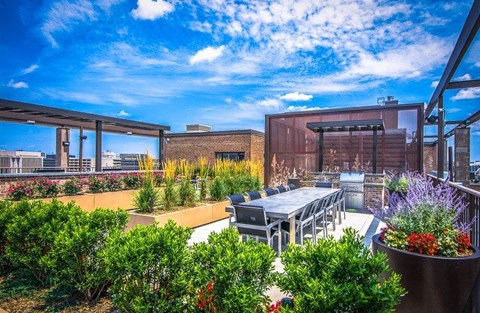 A patio with a table and chairs overlooks a cityscape.