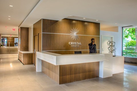 A reception area with a person standing behind the desk.