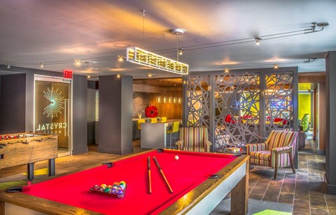 A pool table with a red cloth and a pool cue on it.