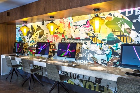 A room with a long table and chairs with a wall covered in posters.