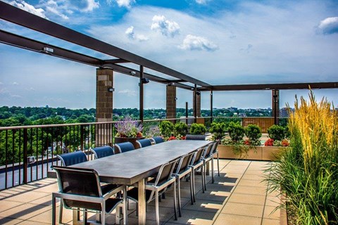 A rooftop with a long table and chairs