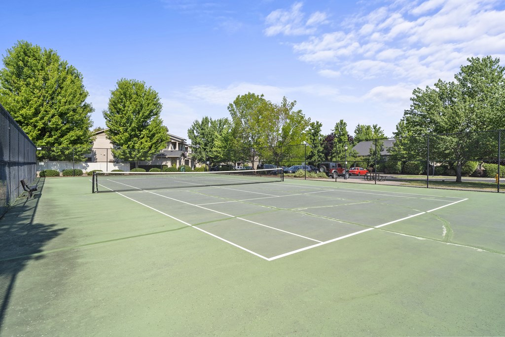 a tennis court at the whispering winds apartments in pearland, tx