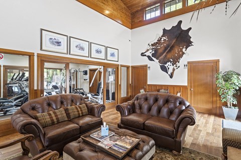 a living room with leather furniture and a map on the wall