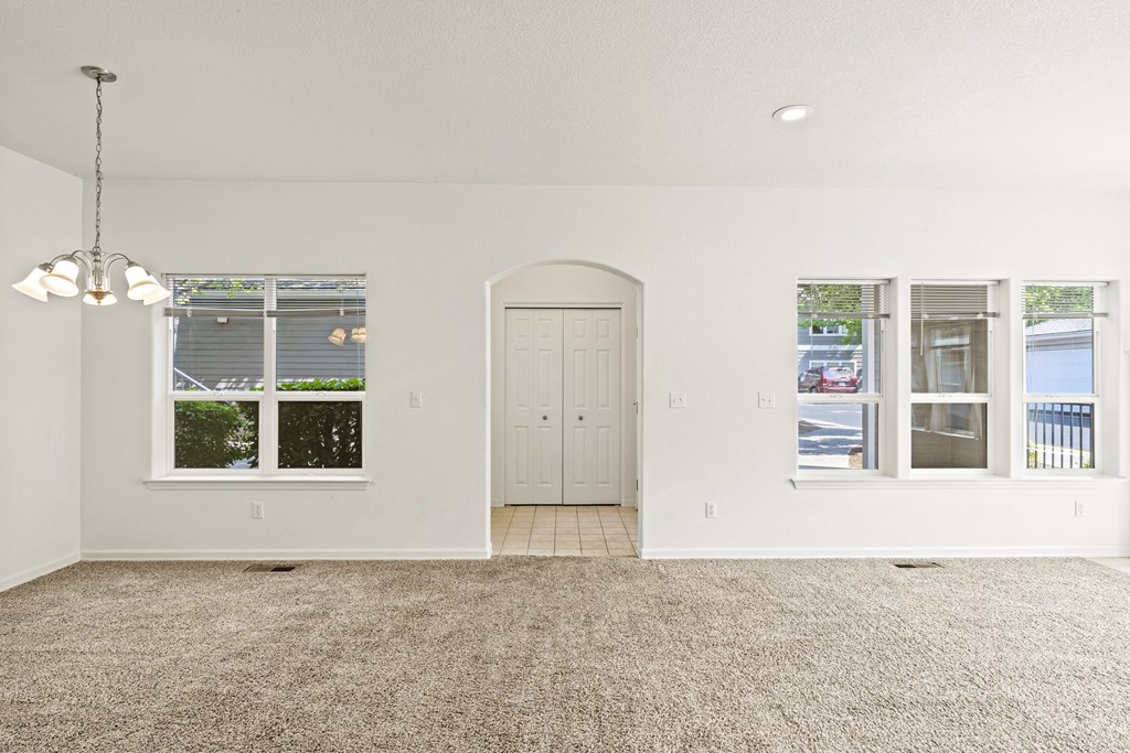 a living room with white walls and a carpeted floor