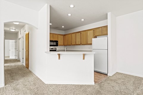 a white kitchen with a white counter top and a white refrigerator
