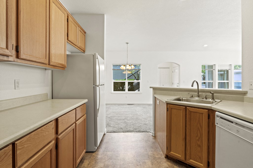 a kitchen with wooden cabinets and white appliances
