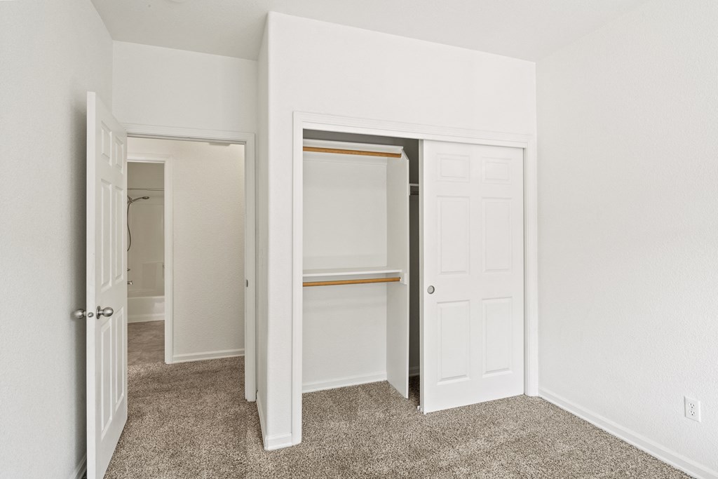 a bedroom with white walls and a carpeted floor