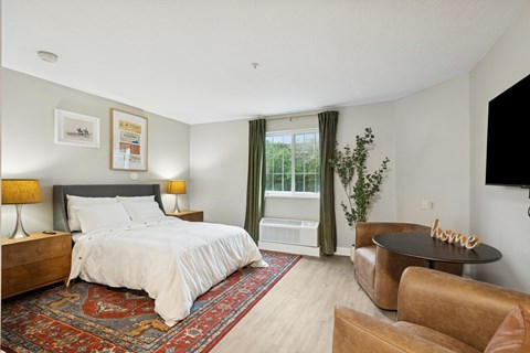 A bedroom with a large bed and a brown leather chair.