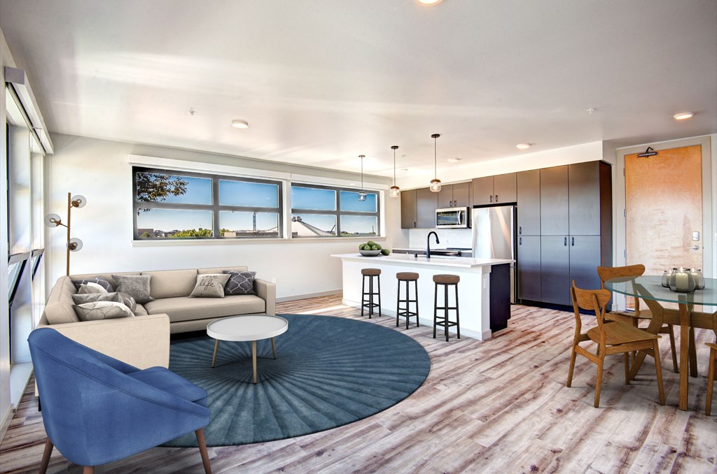 a living room and kitchen with a blue rug