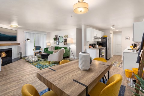 A modern dining room with a wooden table and yellow chairs.