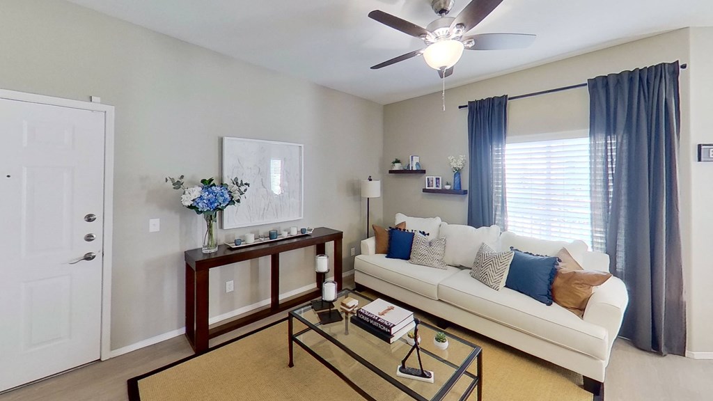 a living room with a white couch and a glass coffee table