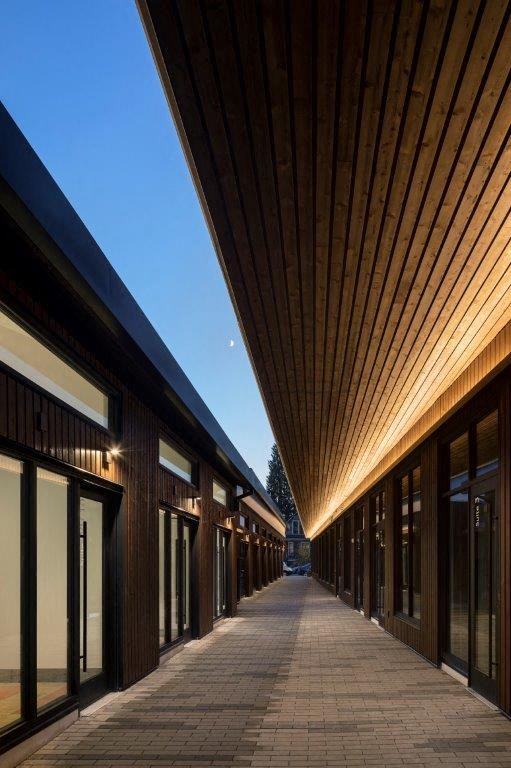 a long corridor with windows and a sidewalk