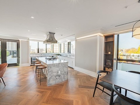 a kitchen with a marble island and a table with chairs