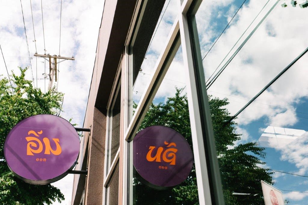 the windows of a ups store with purple signs in the window