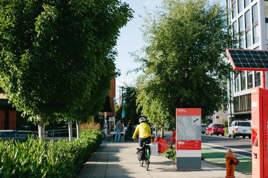 a man riding a bike down a sidewalk