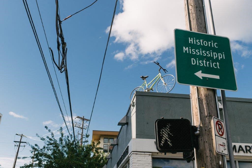 a street sign and a bike on the roof of a building