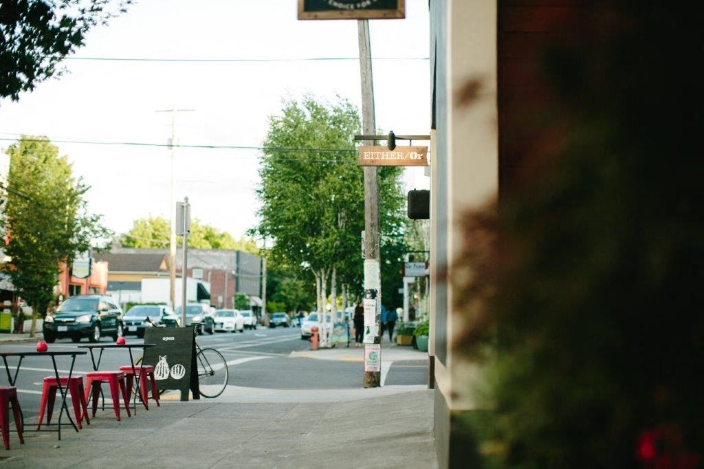 a street with tables and chairs and a bike parked on the sidewalk