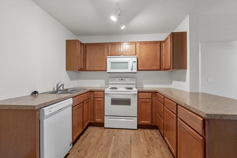 A kitchen with wooden cabinets and white appliances.