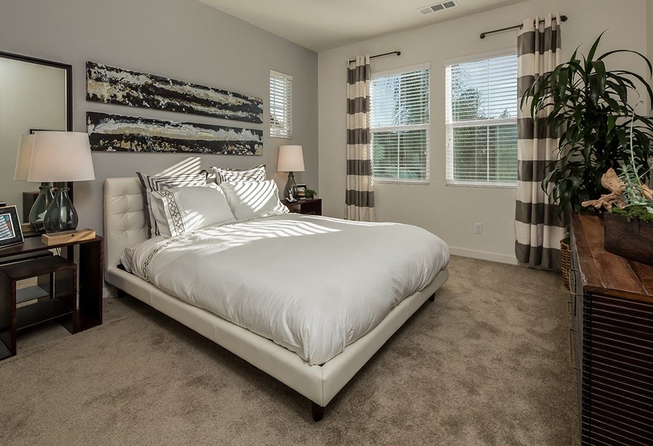 a bedroom with a white bed and a large window