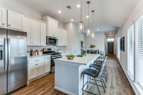 a kitchen with a large island and a stainless steel refrigerator