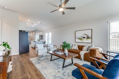 a living room with furniture and a ceiling fan