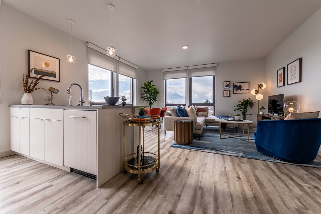 A modern kitchen with a wooden floor and white cabinets.
