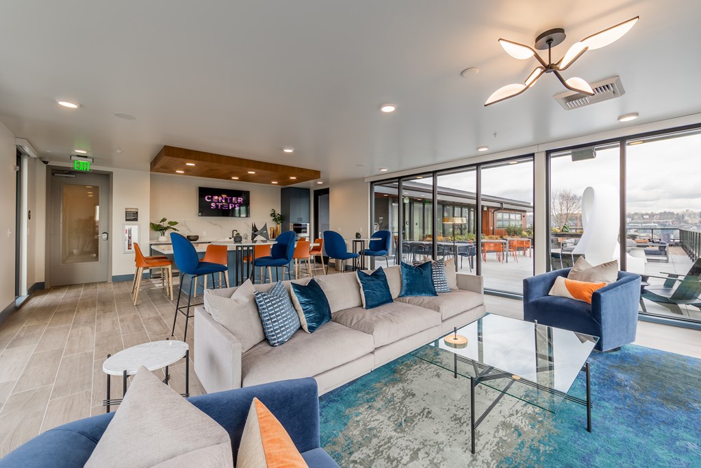 A living room with a sofa, chairs, and a ceiling fan.