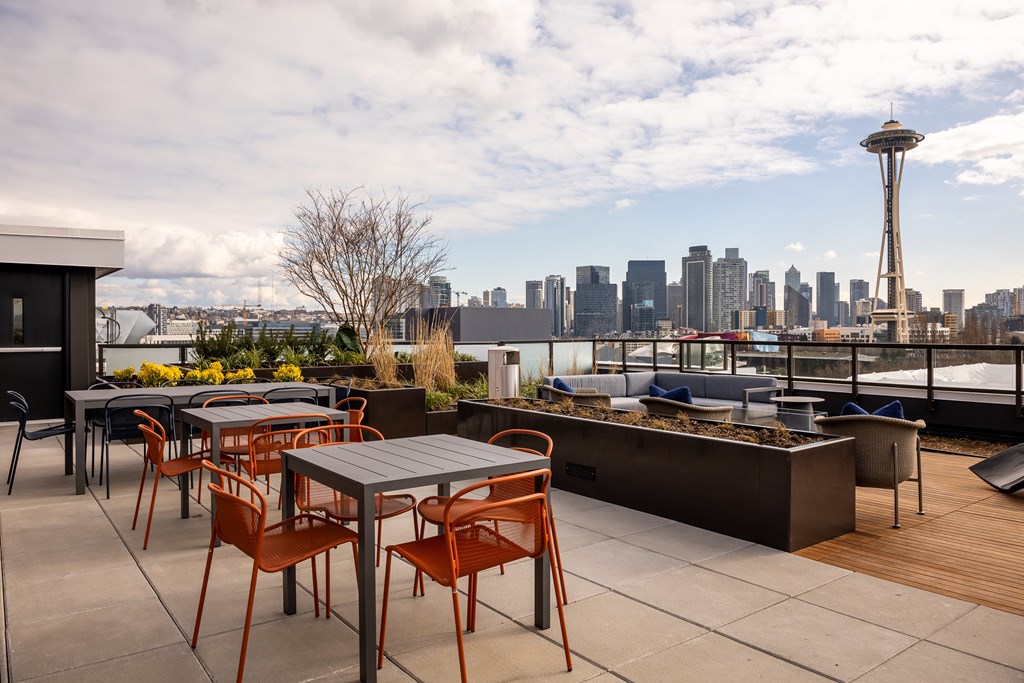 A patio with a table and chairs overlooking a city skyline.