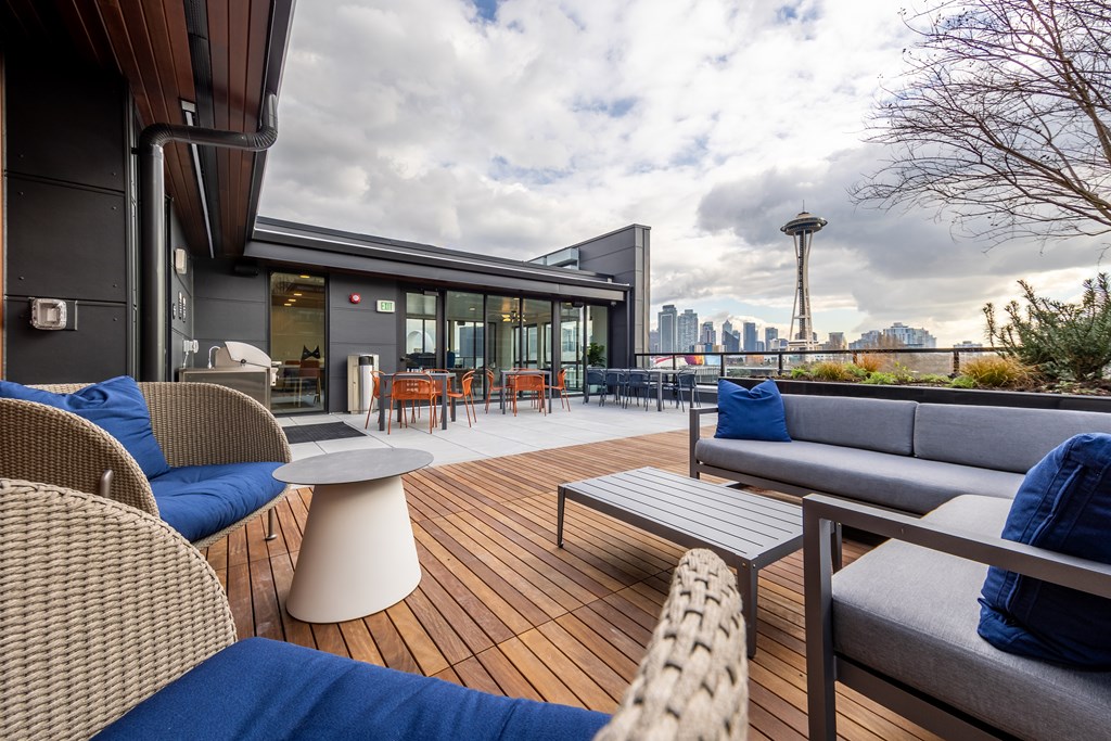 A modern outdoor seating area with a view of the city skyline.