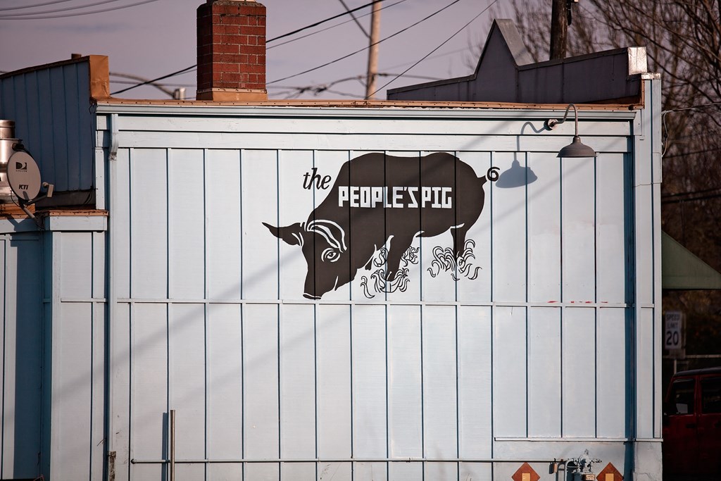 a sign on the side of a building with a cow on it
