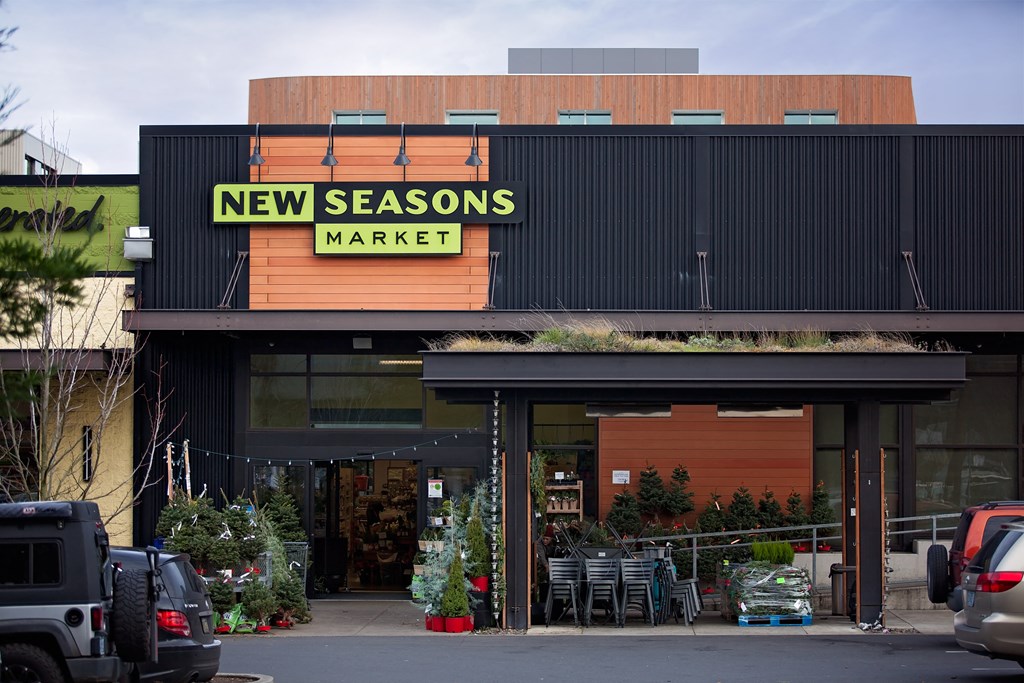 the front of new seasons market with cars parked outside