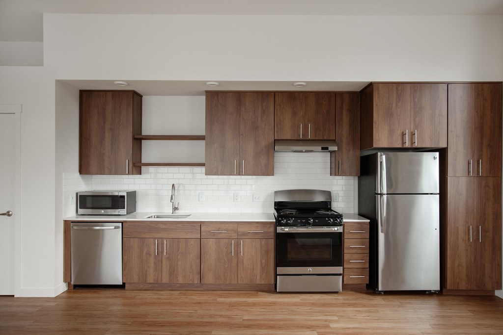 a kitchen with wooden cabinets and stainless steel appliances