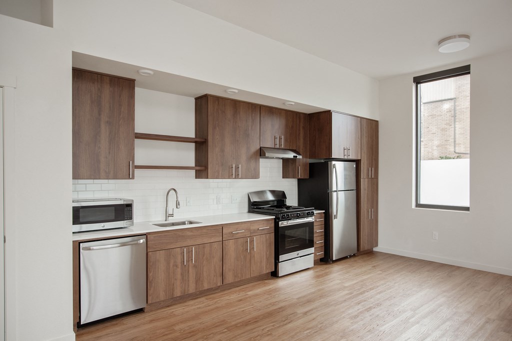 a kitchen with wooden cabinets and stainless steel appliances and a window