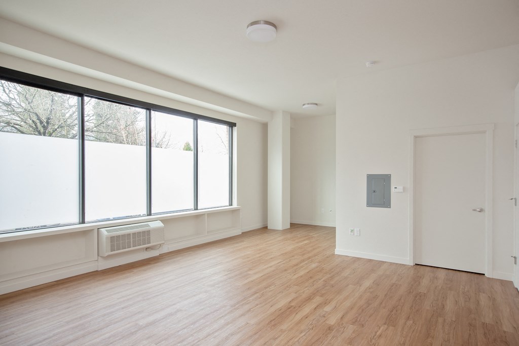 a living room with a large window and wood floors