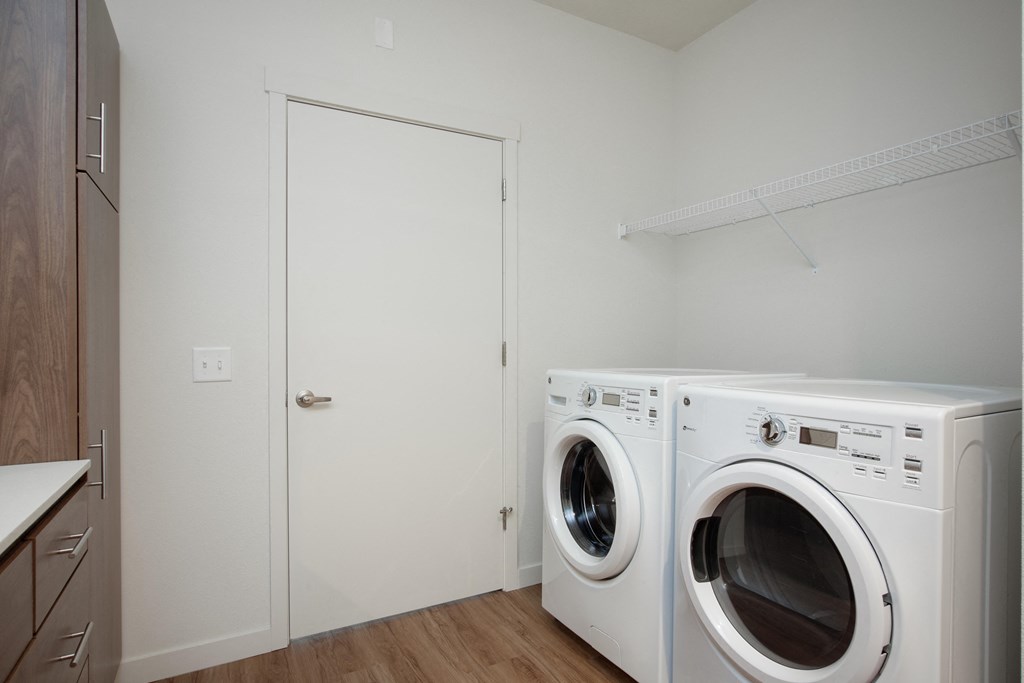 a washer and dryer in a laundry room with a white door