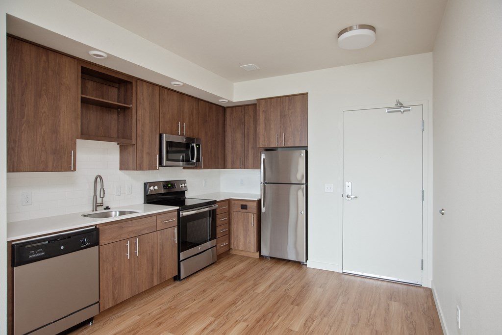 an empty kitchen with wooden cabinets and stainless steel appliances