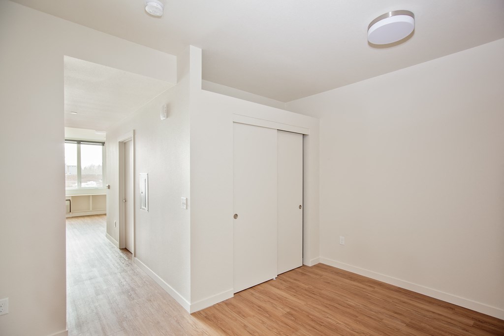 a living room with white walls and a wood floor