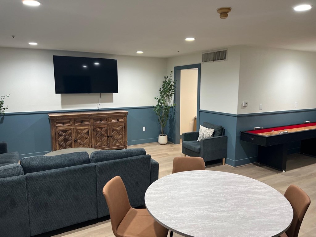 A room with a pool table and a television mounted on the wall.