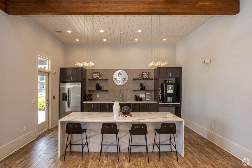 a kitchen with a large island with four chairs around it