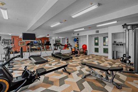 On-site fitness center with machines, weights, and tv at Collins Circle apartments in the Goose Hollow district in Portland, Oregon.