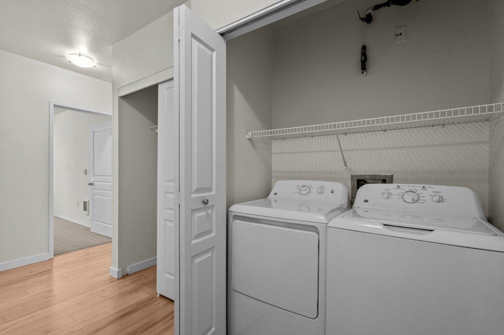 a washer and dryer in a room with a door to a closet