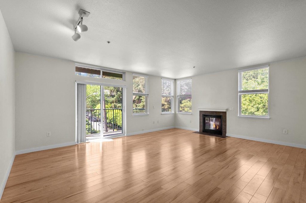 an empty living room with a wood floor and a fireplace