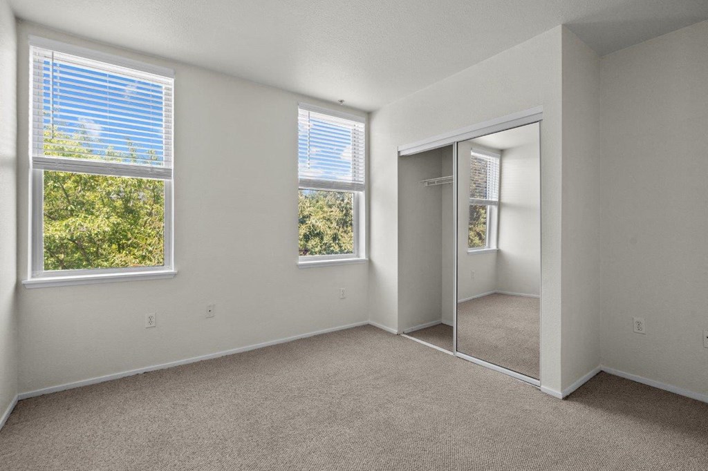 a bedroom with a mirror and a door to a closet
