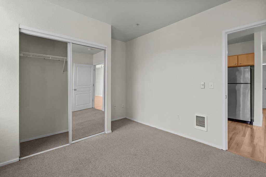 a bedroom with a closet and a mirrored door