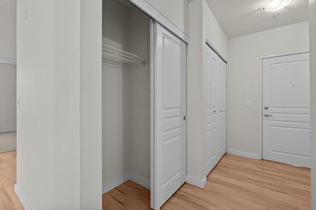 a bedroom with two closets and a hard wood floor