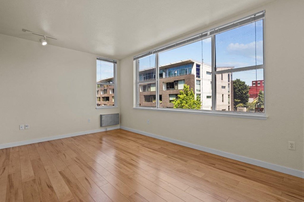 a living room with a large window and wooden floors
