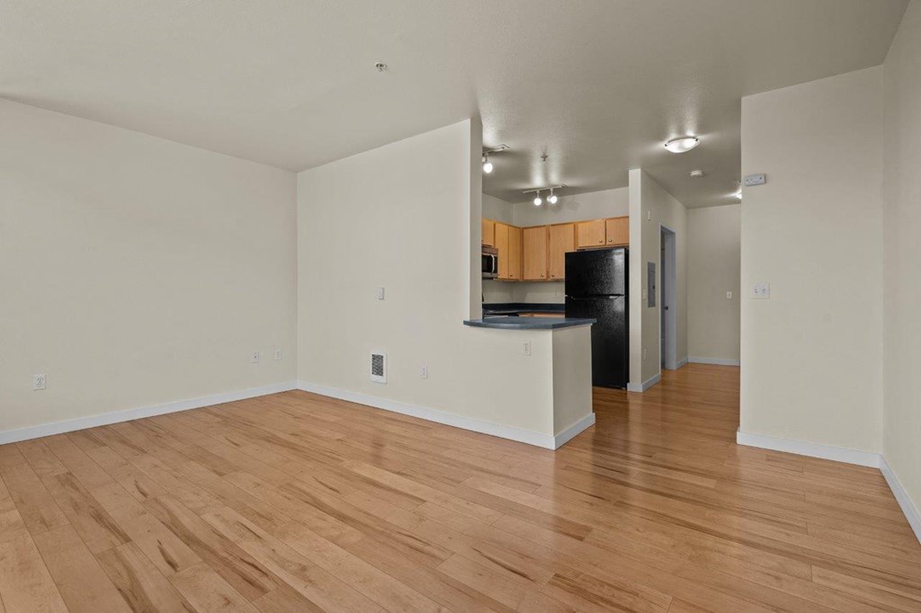 a living room and kitchen with a hard wood floor